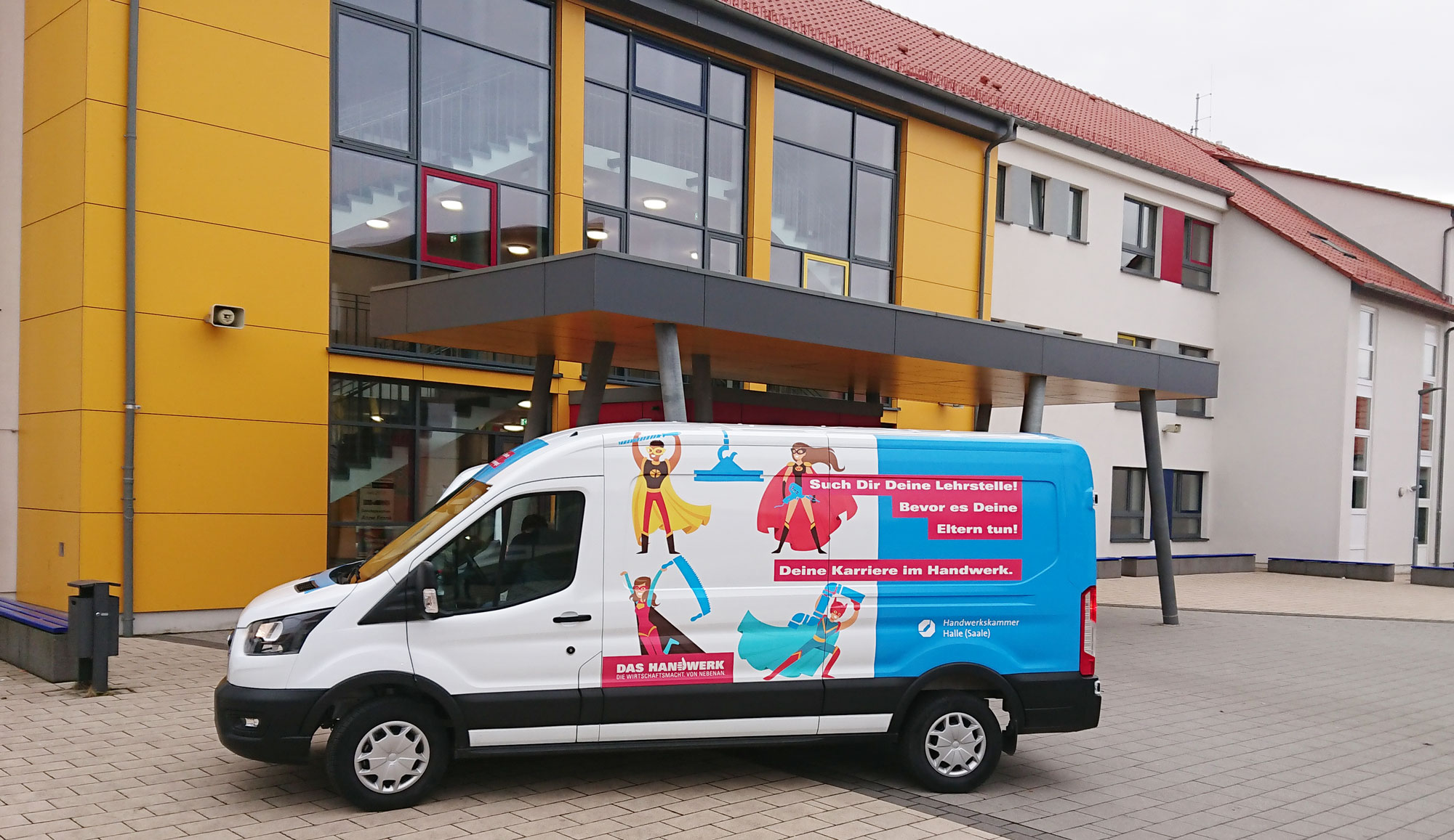 Schoolworker-Mobil vor einer Schule