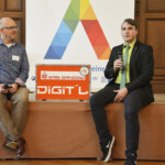 Erstplatzierter Erik Köhler (r.) erläutert dem Publikum auf der Auszeichnungsveranstaltung seine Erfindung. Rechts: Moderator und Projektleiter Norman Balke.