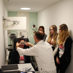 Glenn Daucher, Inhaber von Scheffler Optik, erklärt den Schülerinnen Magdalena Namsdek (Mitte) und Emma Reinfrank (r.), was der Beruf Augenoptiker alles umfasst.